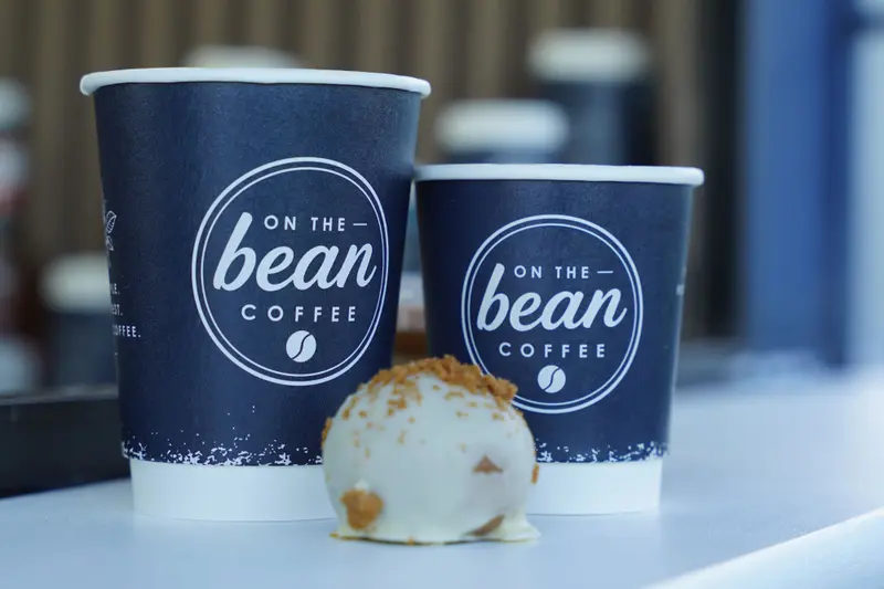Two On the Bean coffees and a protein ball on the counter